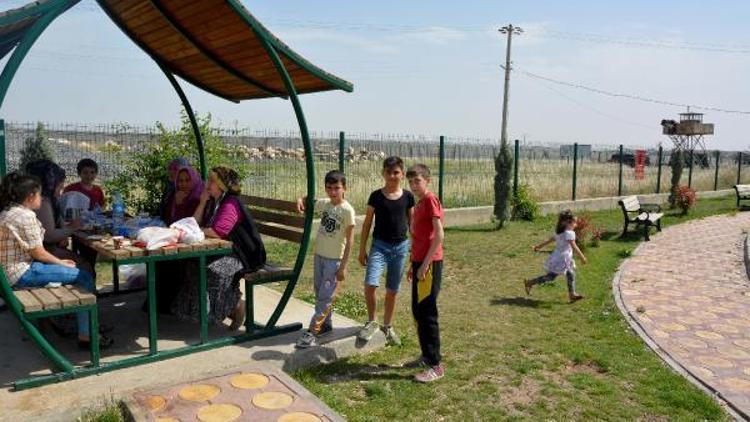 Sınırda asker eli tetikte görev yapıyor, çocuklar ise parkta oynuyor