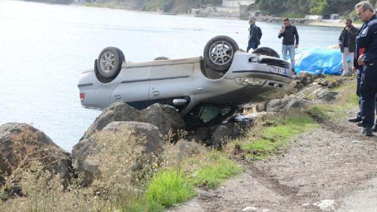 Otomobil deniz kenarındaki kayalıklarda ters halde kaldı