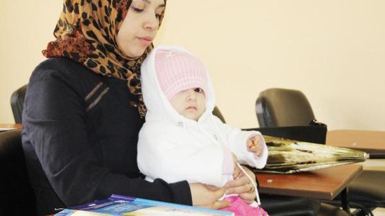 Suriyeli Pervin, kucağında 1 yaşındaki kızı ile okuma-yazma kursunda