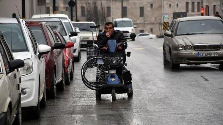Akülü engelli aracıyla tekerlekli sandalye taşıyor