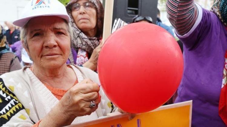 Kadınlar kırmızı balonları mor iğnelerle patlattı