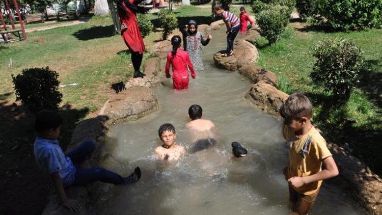 Sıcaktan bunalan çocuklar, süs havuzunda serinliyor