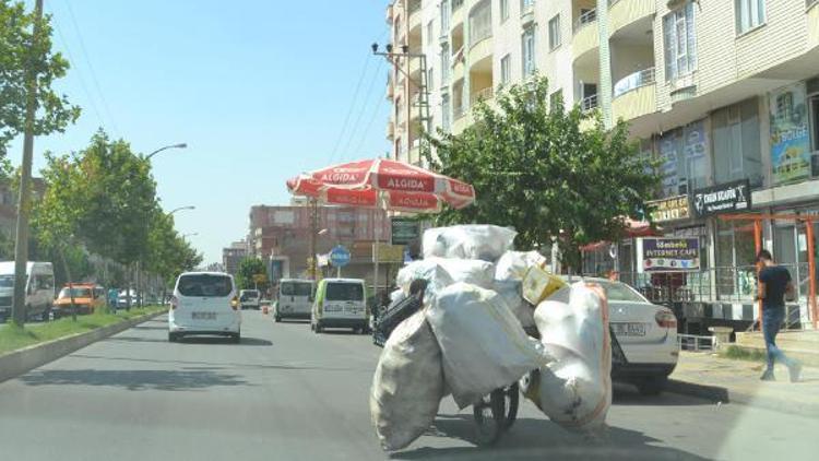 Eskici, güneşten şemsiye ve şapka ile korunuyor