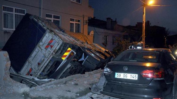 Freni boşalan kamyon evin bahçesine devrildi