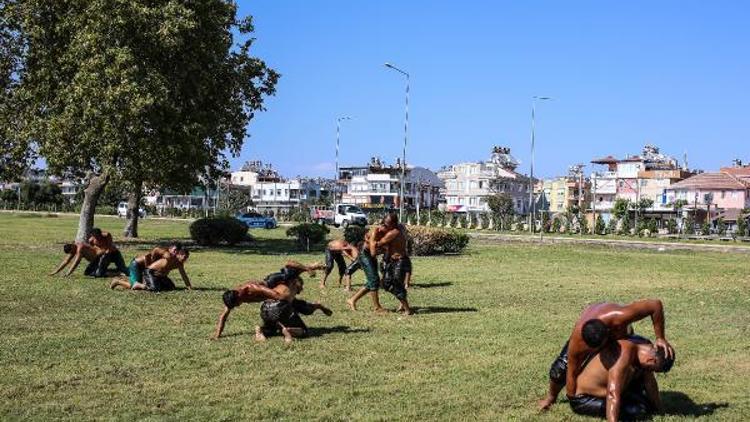 Güreşçiler, yol kenarındaki çimde antrenman yapıyor