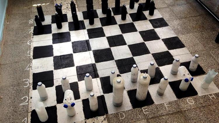 Öğrencileri için pet şişeleri keserek satranç takımı yaptı