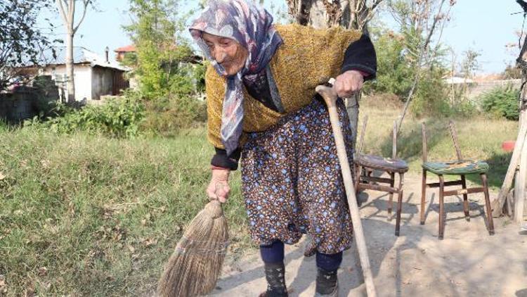 118 yaşındaki nine, evinin yolunu süpürüyor
