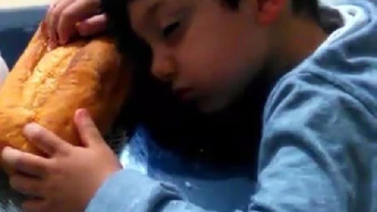 Sofrada ekmekle uyuklayan çocuk, ilgi odağı oldu