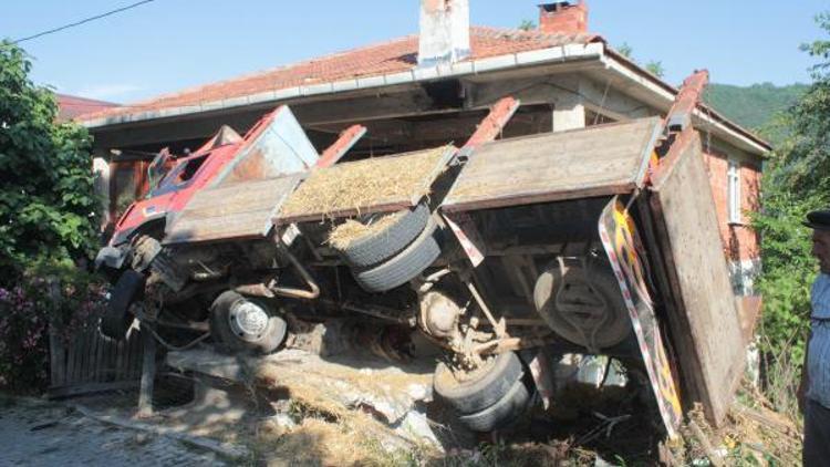 Freni boşalan kamyon, otomobil ile eve çarpıp devrildi