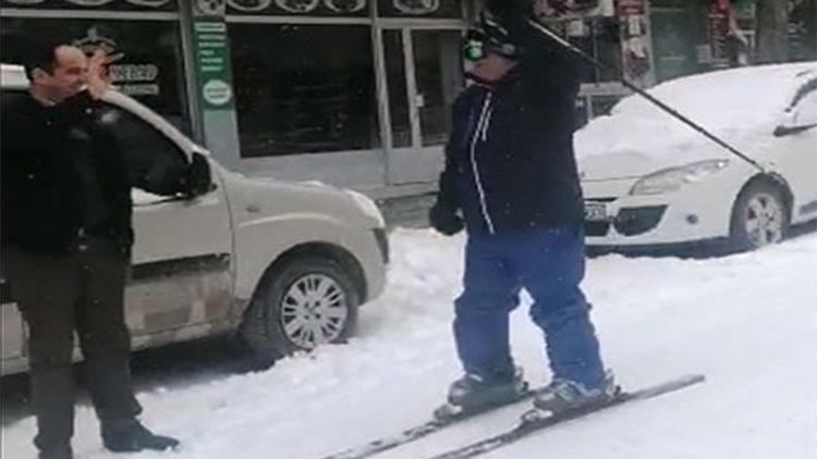 Karla kaplanan cadde üzerinde kayak yaptı