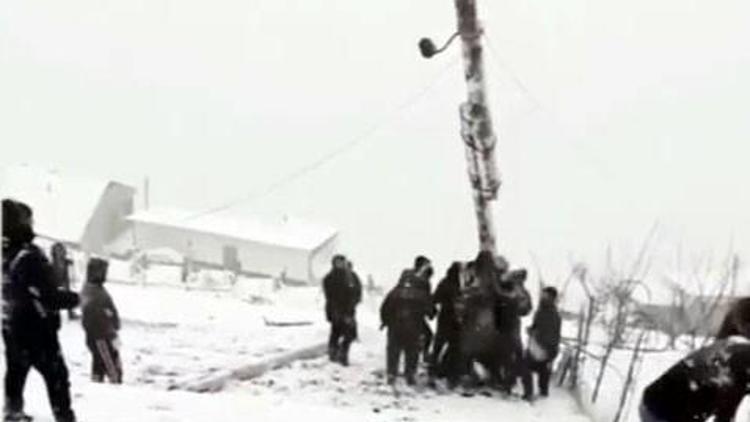 Rusyada devrilen elektrik direğini kaldırmaya çalışan köylülerin zor anları