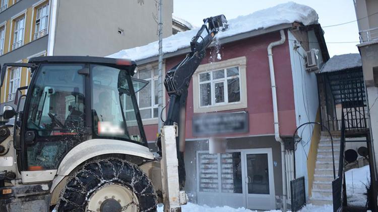 Kepçeyle çatıdaki karları temizlediler