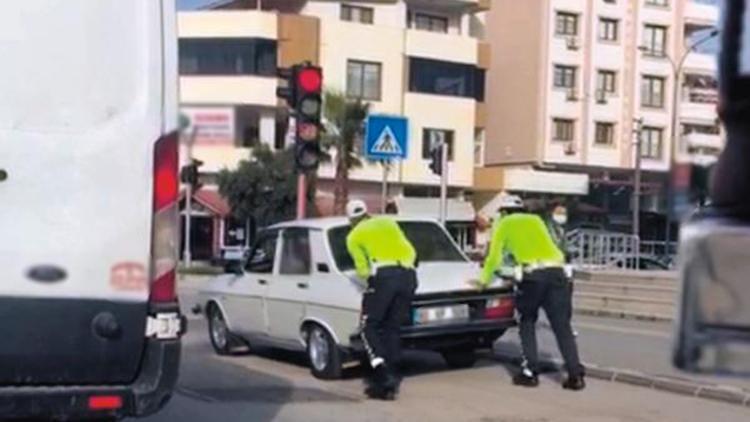 Trafik polisleri, yolda kalan sürücünün otomobilini itti