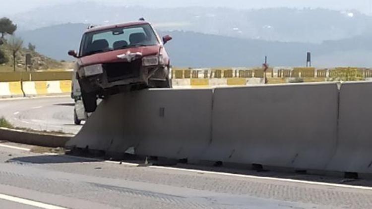 Refüjdeki beton bariyere çıkan otomobil, asılı kaldı