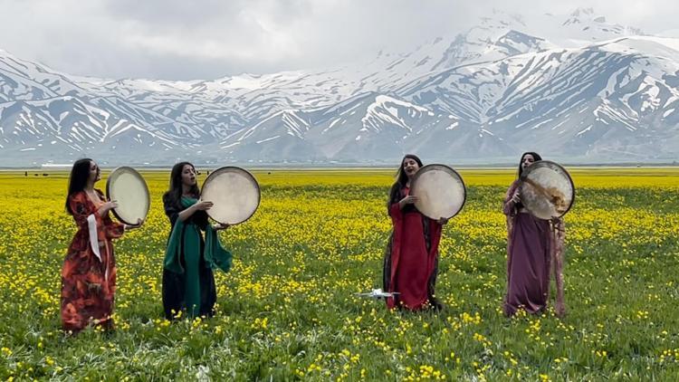 Karlı dağlar ve sarı çiçekler arasında erbane provası