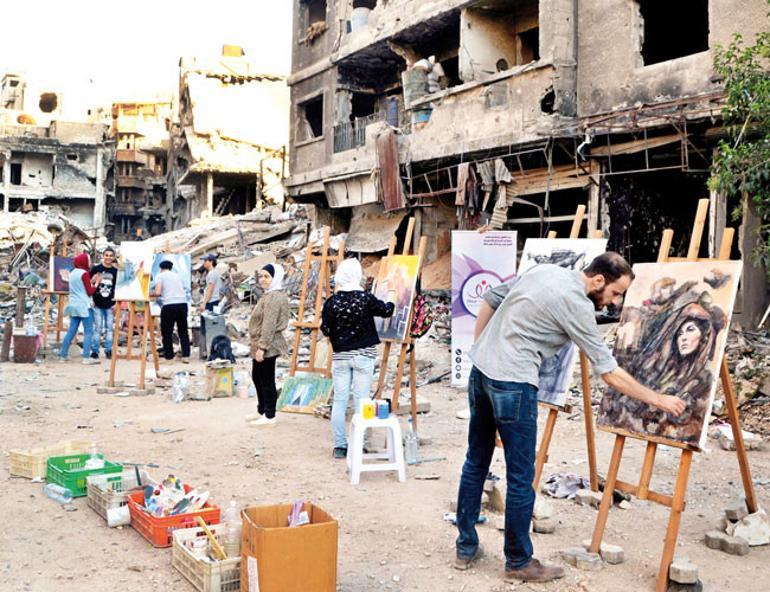 In Syria’s Yarmuk, artists paint amid the ruins