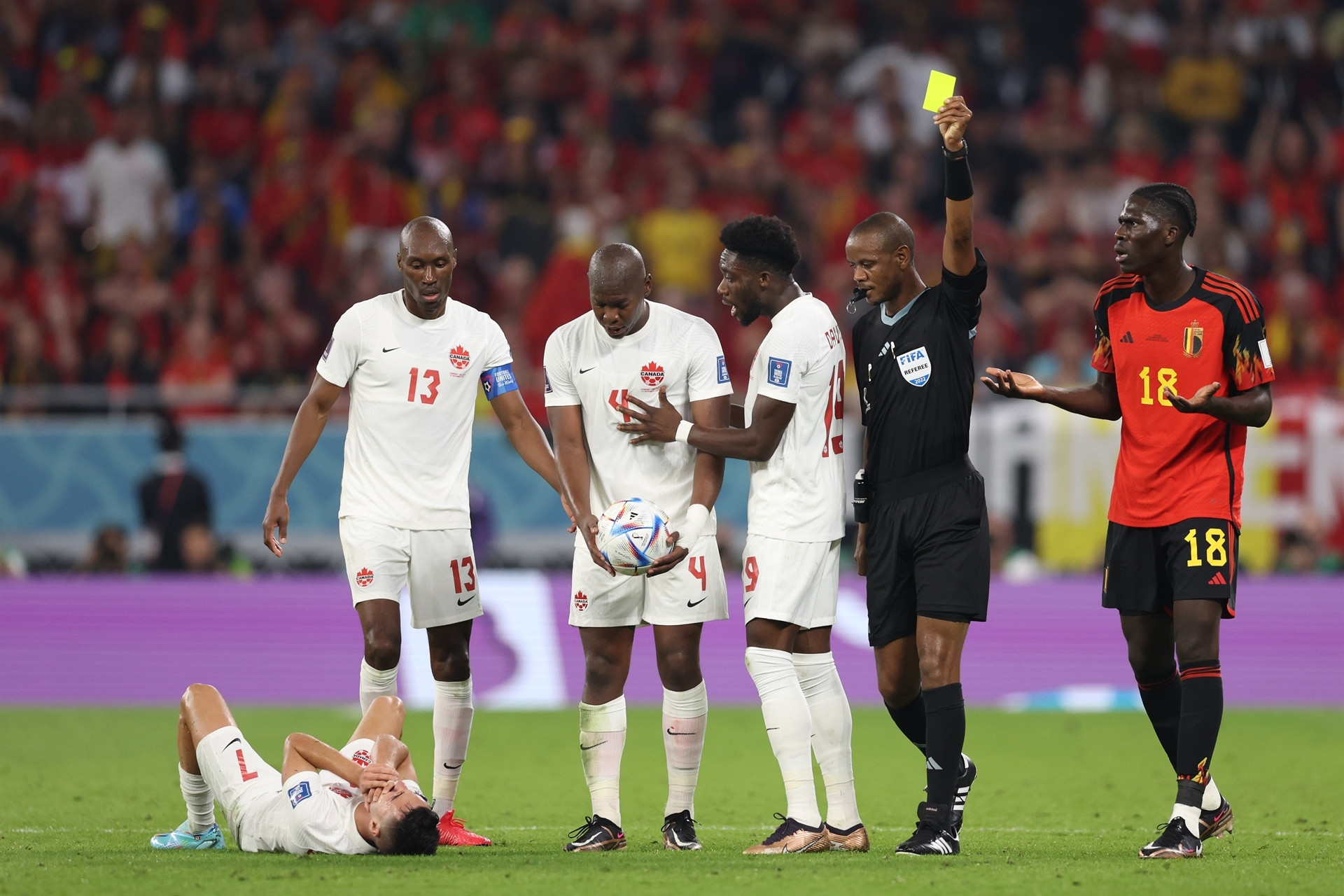 DOHA, QATAR - NOVEMBER 23: Referee Janny Sikazwe shows a yellow card to Amadou Onana of Belgium after his challenge on Stephen Eustaquio of Canada during the FIFA World Cup Qatar 2022 Group F match between Belgium and Canada at Ahmad Bin Ali Stadium on November 23, 2022 in Doha, Qatar. (Photo by Clive Brunskill/Getty Images)
