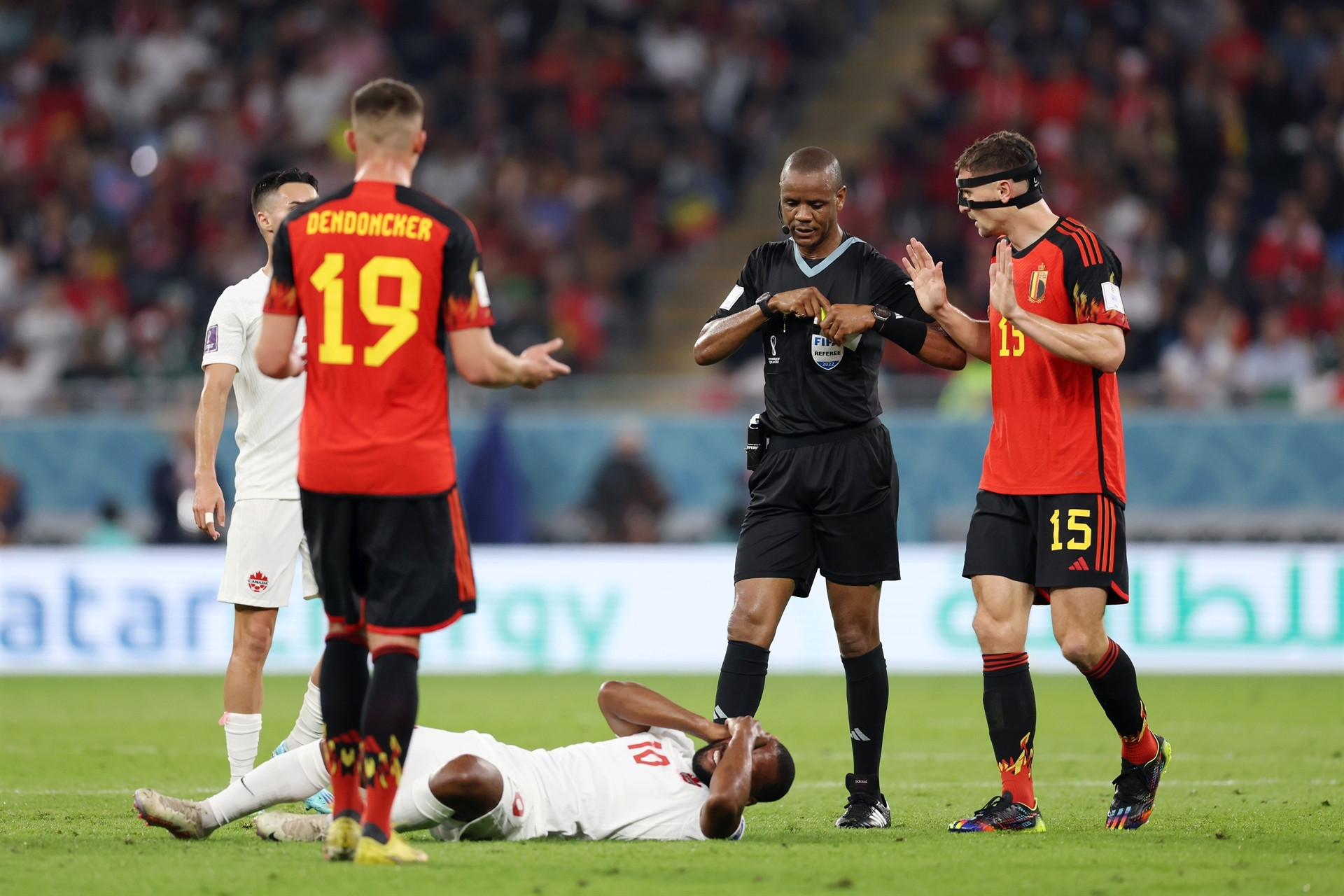 DOHA, QATAR - NOVEMBER 23: Referee Janny Sikazwe prepares to show a yellow card to Thomas Meunier of Belgium after his challenge on Junior Hoilett of Canada during the FIFA World Cup Qatar 2022 Group F match between Belgium and Canada at Ahmad Bin Ali Stadium on November 23, 2022 in Doha, Qatar. (Photo by Clive Brunskill/Getty Images)
