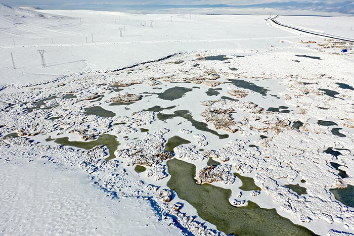  Göçmen kuşların rotası olan göl dondu, evler beyaz örtüyle kaplandı