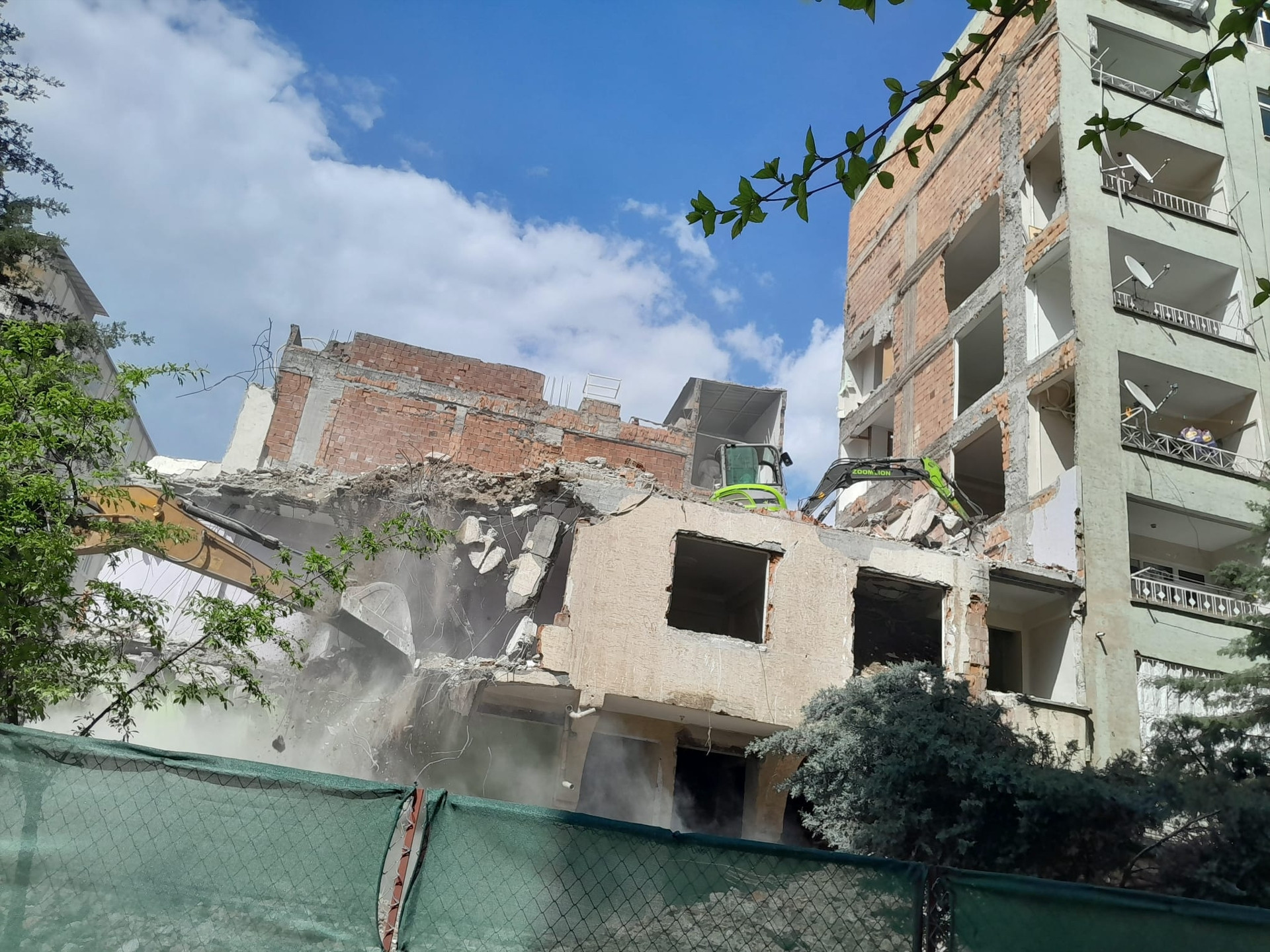 Depremde ağır hasar alan bina yıkıldı, bitişikteki apartmanın bazı odaları duvarsız kaldı Mecburen bu hasarlı evin içinde kalıyoruz