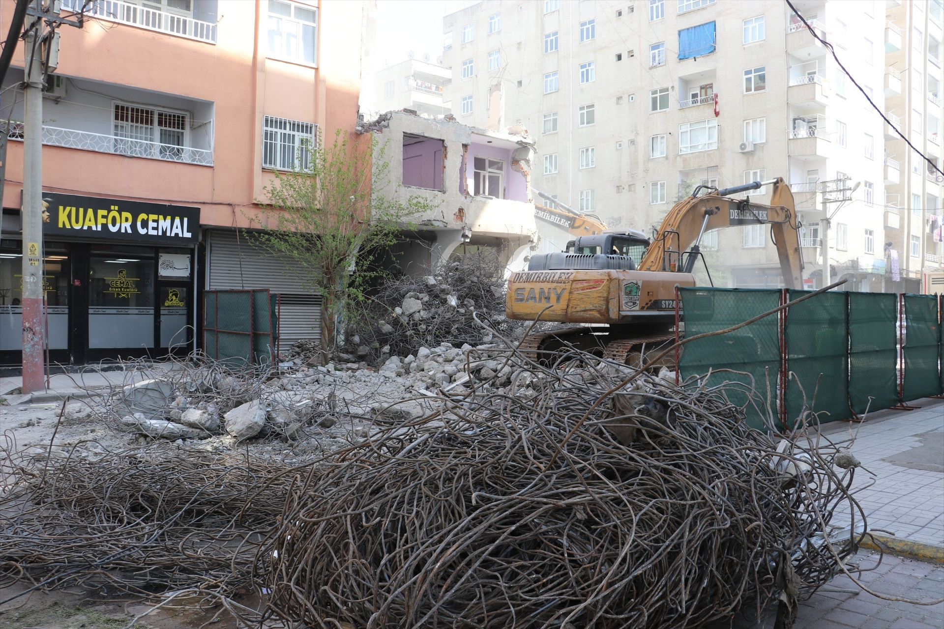 Depremde ağır hasar alan bina yıkıldı, bitişikteki apartmanın bazı odaları duvarsız kaldı Mecburen bu hasarlı evin içinde kalıyoruz