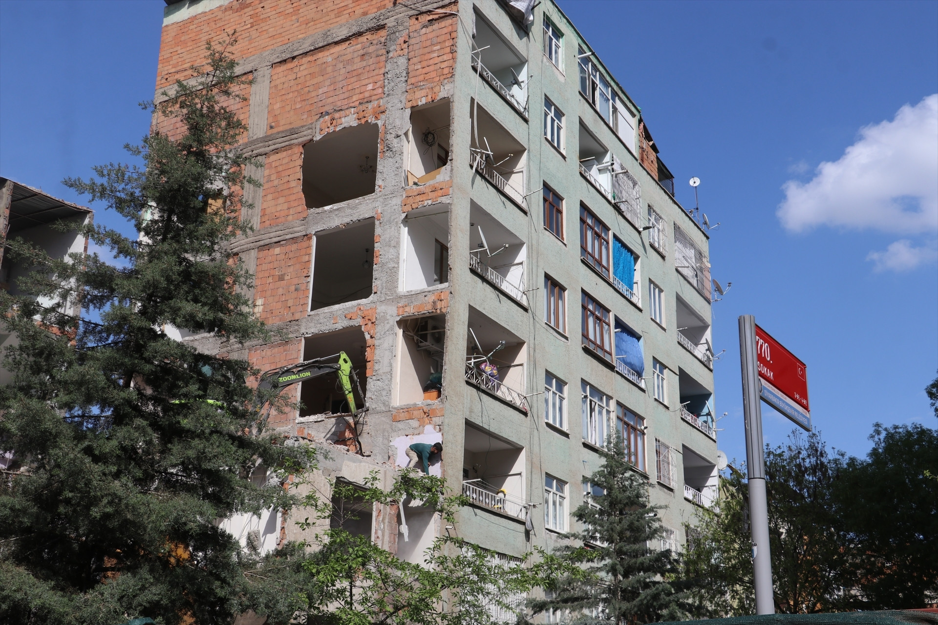 Depremde ağır hasar alan bina yıkıldı, bitişikteki apartmanın bazı odaları duvarsız kaldı Mecburen bu hasarlı evin içinde kalıyoruz