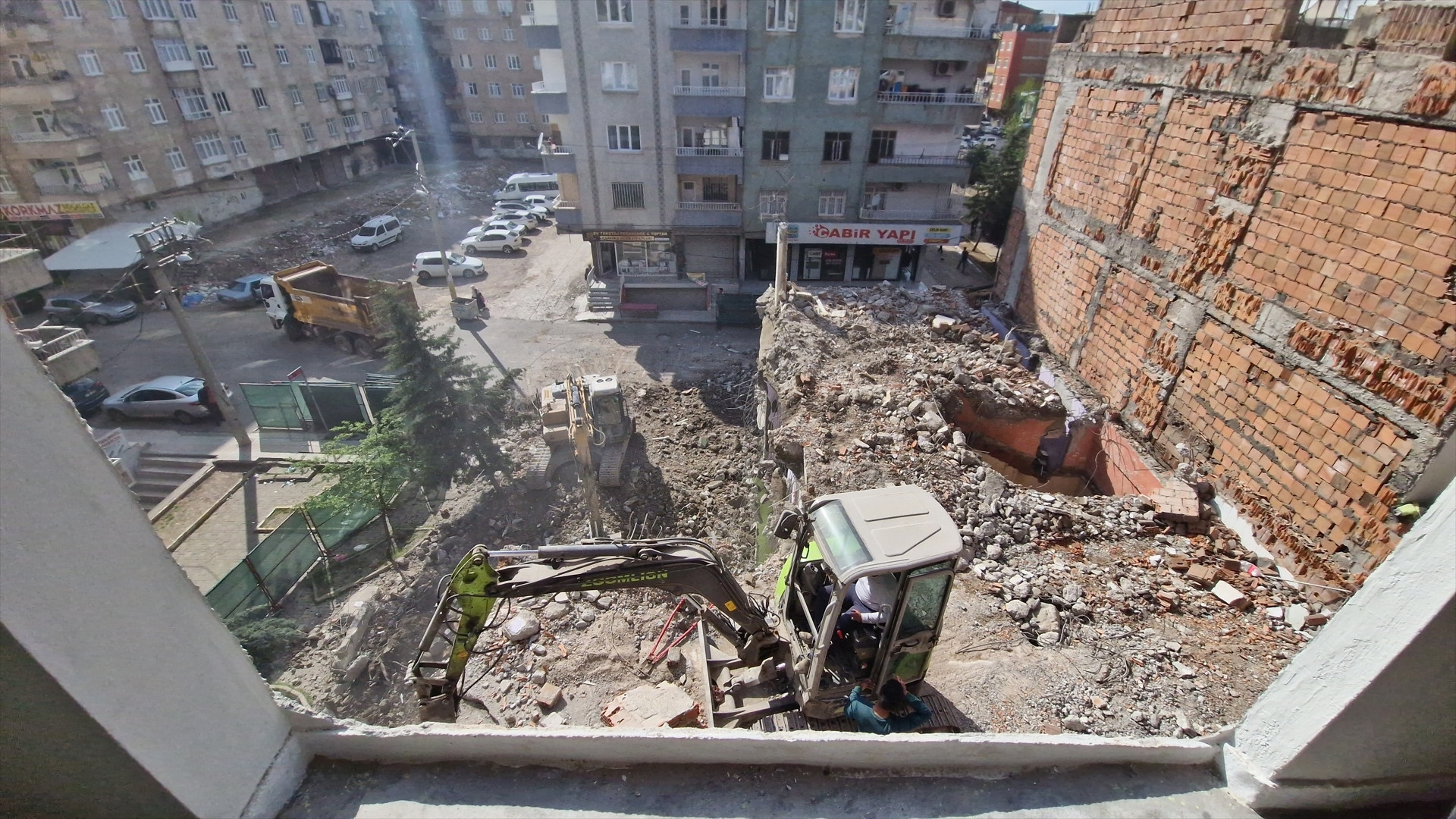 Depremde ağır hasar alan bina yıkıldı, bitişikteki apartmanın bazı odaları duvarsız kaldı Mecburen bu hasarlı evin içinde kalıyoruz