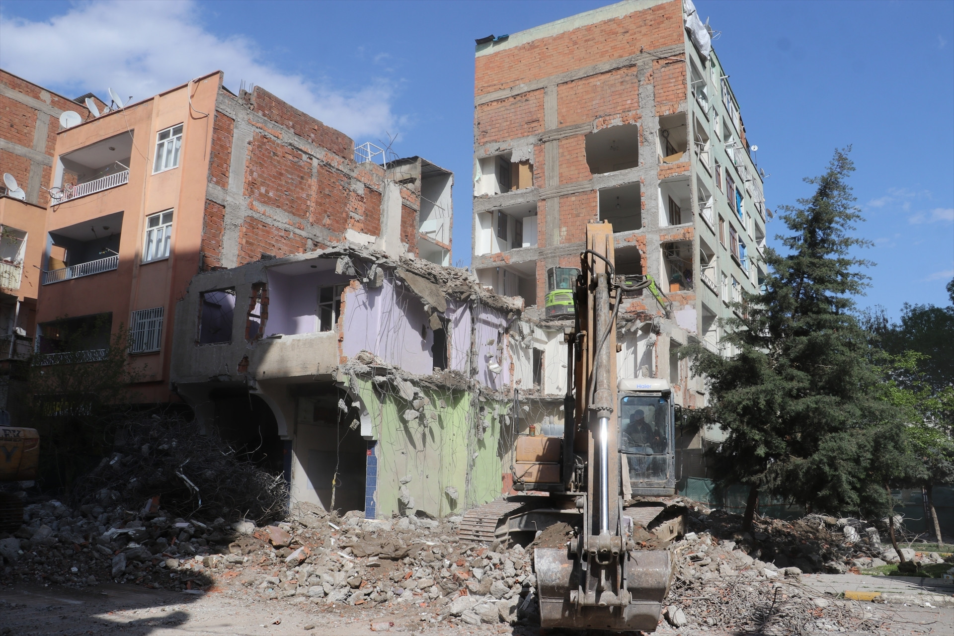 Depremde ağır hasar alan bina yıkıldı, bitişikteki apartmanın bazı odaları duvarsız kaldı Mecburen bu hasarlı evin içinde kalıyoruz