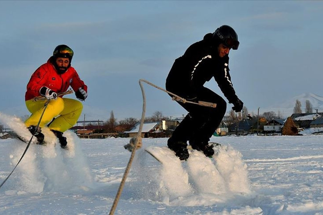 Arazi aracıyla karda snowboard yaptılar