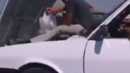 Seyir halindeki otomobile su takviyesi yapan şahıslar kamerada