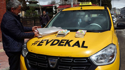 Taksinin çevresine evde kal yazıp, kitap dağıttı