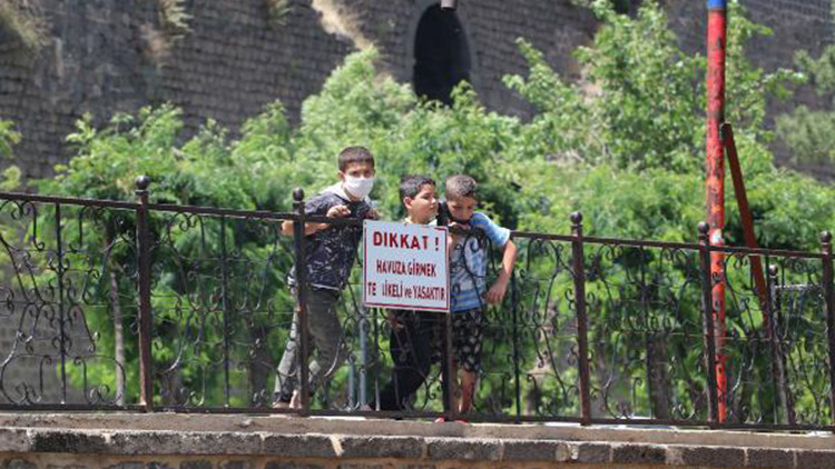 Çocuklar havuza girmek, güvenlik görevlileri ise sokmamak için nöbette