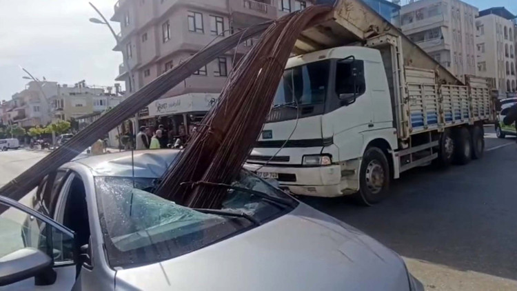 Kamyonun kasasından düşen inşaat demirleri, otomobilin tavanını deldi Kamyonun kasasından düşen inşaat demirleri, otomobilin tavanını deldi