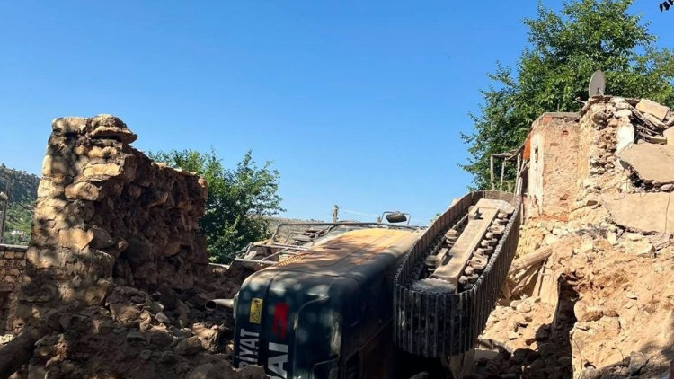 Gercüş’te, metruk evin yıkımı sırasında iş makinesi devrildi