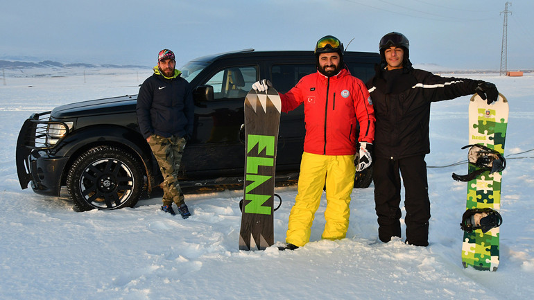 Arazi aracıyla karda snowboard yaptılar