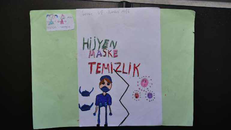 İki kardeş okula gidebilmek için sokaklara koronavirüs bilgi afişleri asıyor