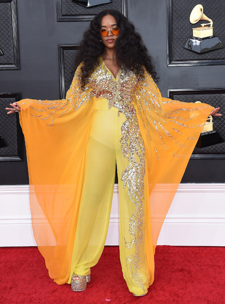 Biri market poşetiyle diğeri buruşuk elbiseyle kırmızı halıda