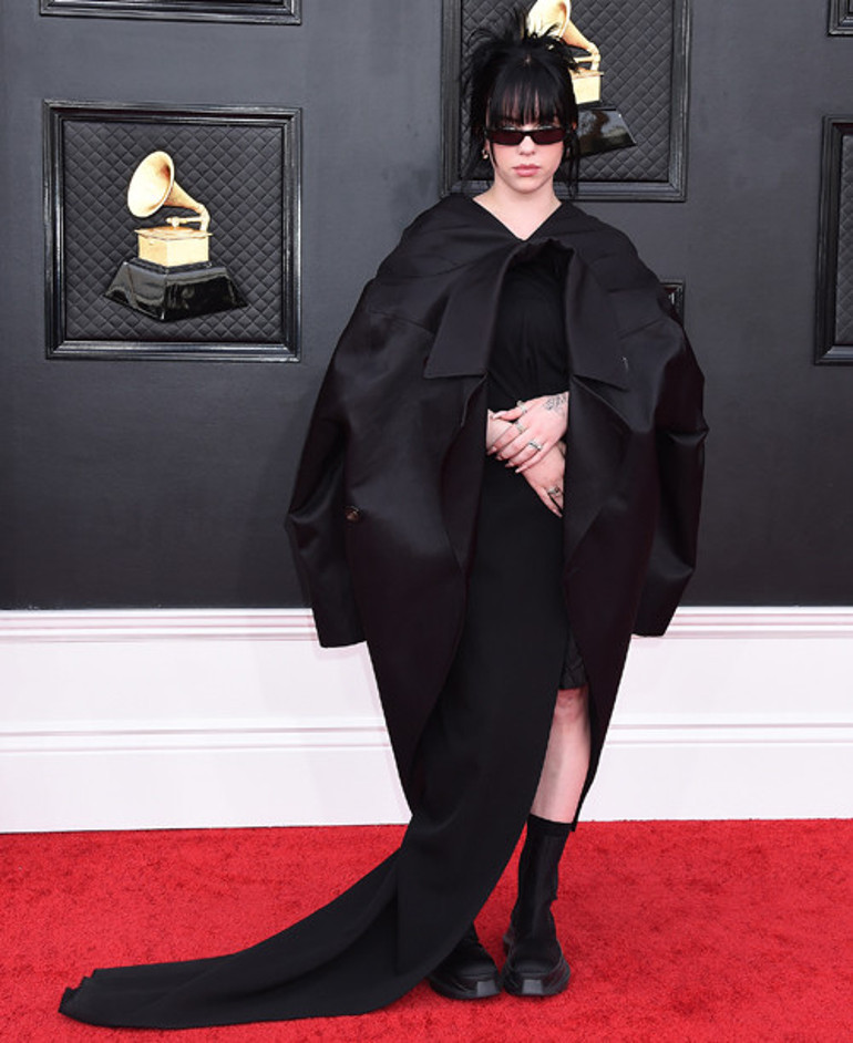 Biri market poşetiyle diğeri buruşuk elbiseyle kırmızı halıda