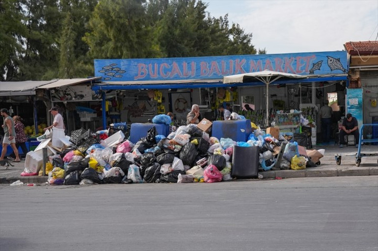 Buca belediyesi önünde eylem yapan işçiler ve sokakta biriken çöpler