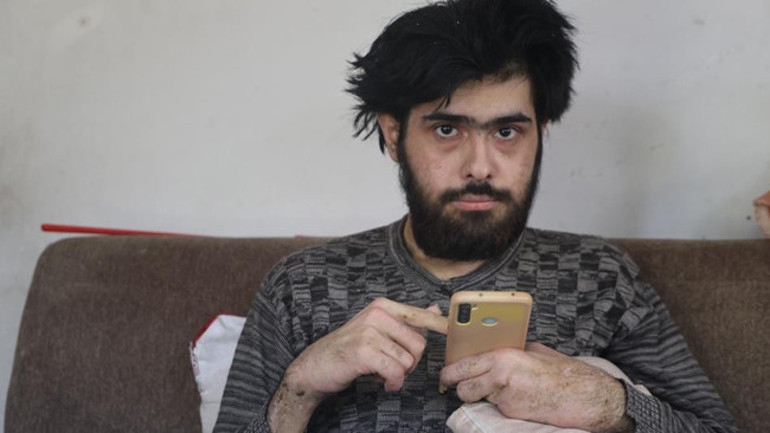 Deprem sonrası evde oturan genç, telefonla zaman geçiriyor