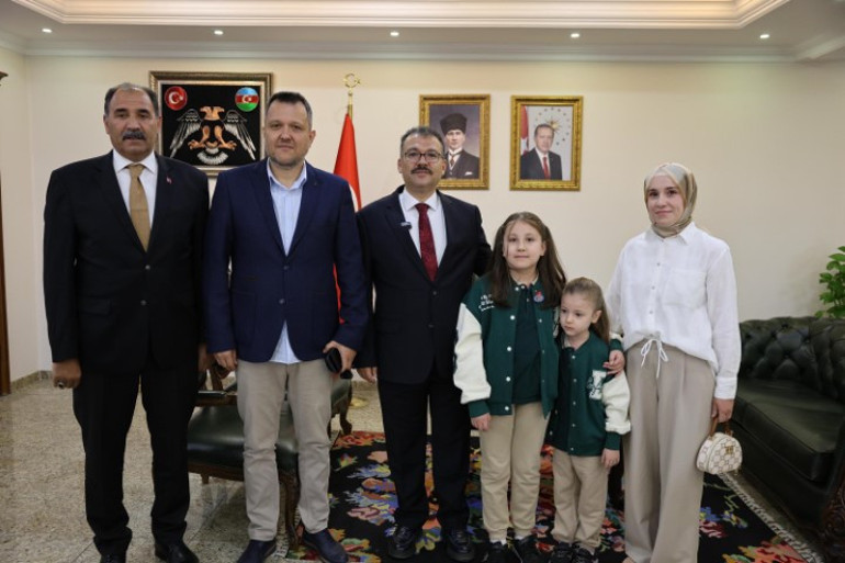 Yağmur altında saygı duruşunda bulunan öğrenci