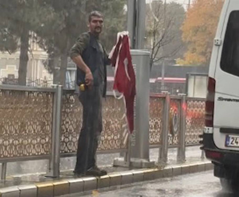 Bayrakları toplayıp korumaya alan kişinin görüntüsü