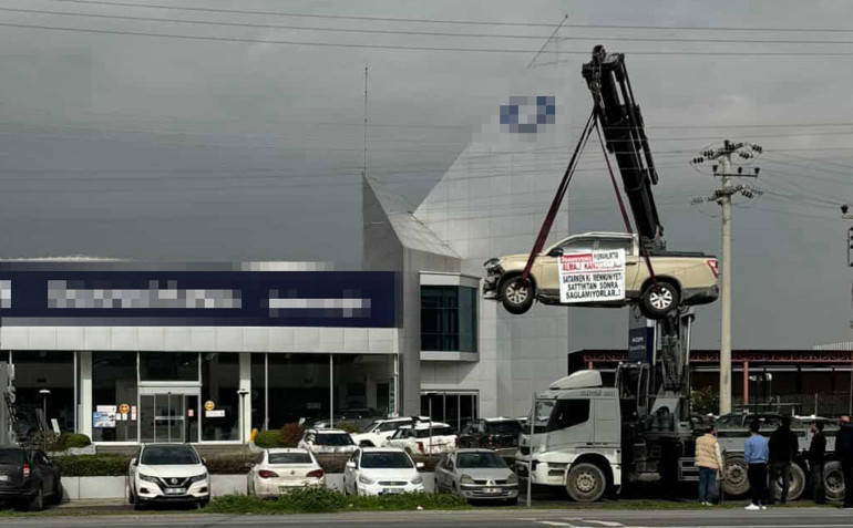 Sıfır araç alan müşteriden ilginç protesto: Üzerine bu notu yazıp vinçle sergiledi