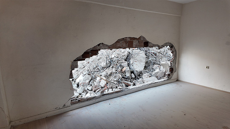 Yıkım sırasında bitişik binadaki dairenin yatak odasının duvarı yıkıldı