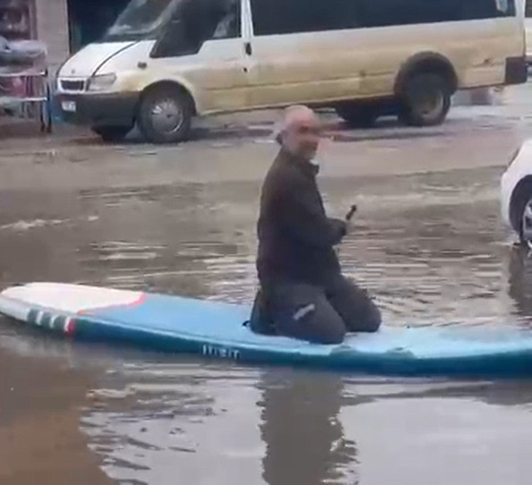 İlçede etkili olan sağanak sonrası sokakları su bastı: Araç tamir ustası SUP board yaptı