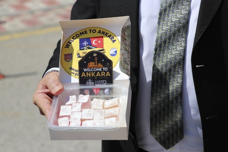 Gri pantolon, beyaz gömlek ve lokum ikram