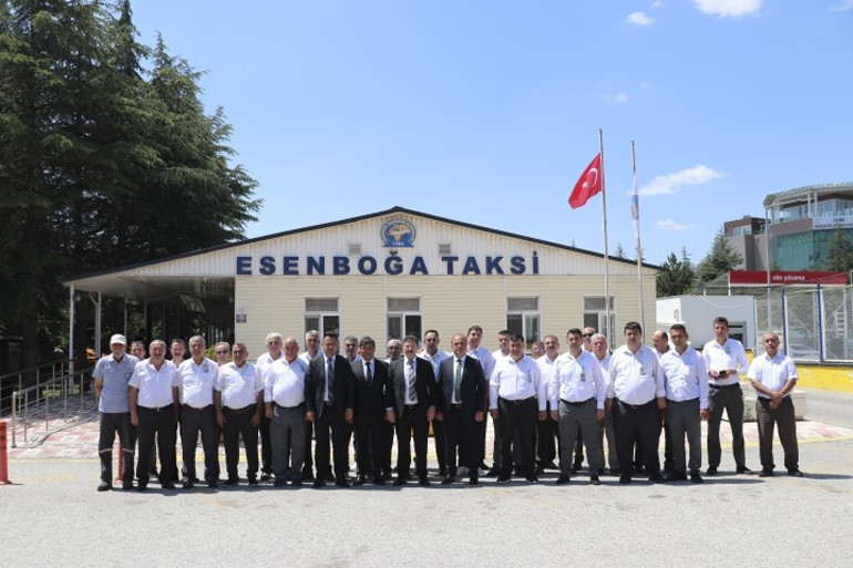 Gri pantolon, beyaz gömlek ve lokum ikram