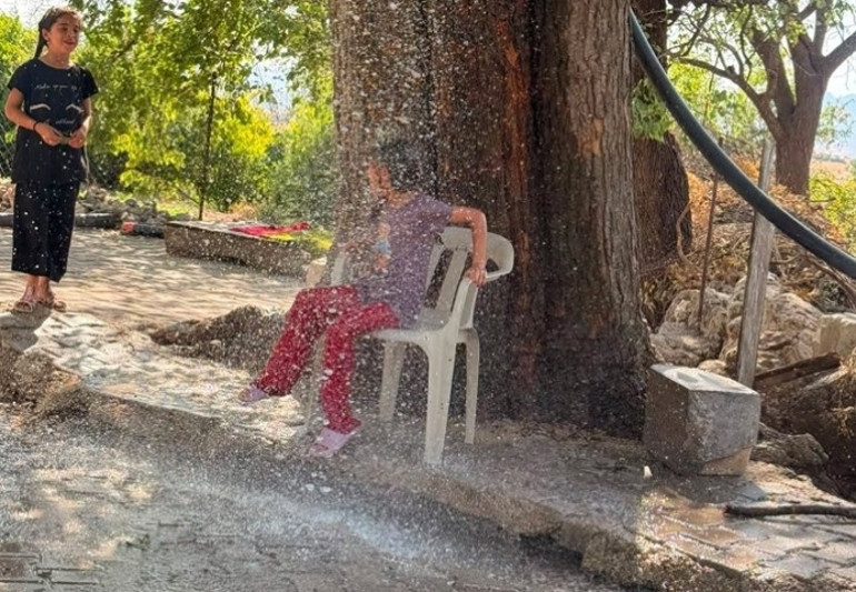 ağaçtan sarkıtılan hortumla serinlediler