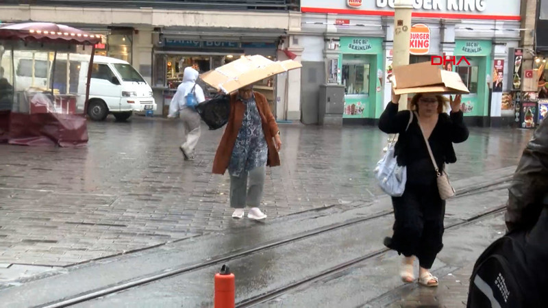 Taksim’de yağmura yakalananlar çanta ve kartonla korunmaya çalıştı