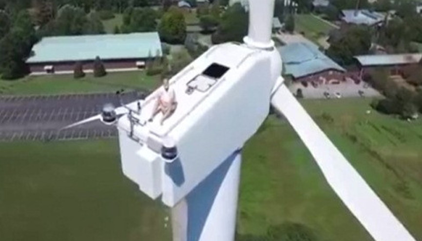 Rüzgar paneli üzerinde güneşlenirken drone yakalanan adam